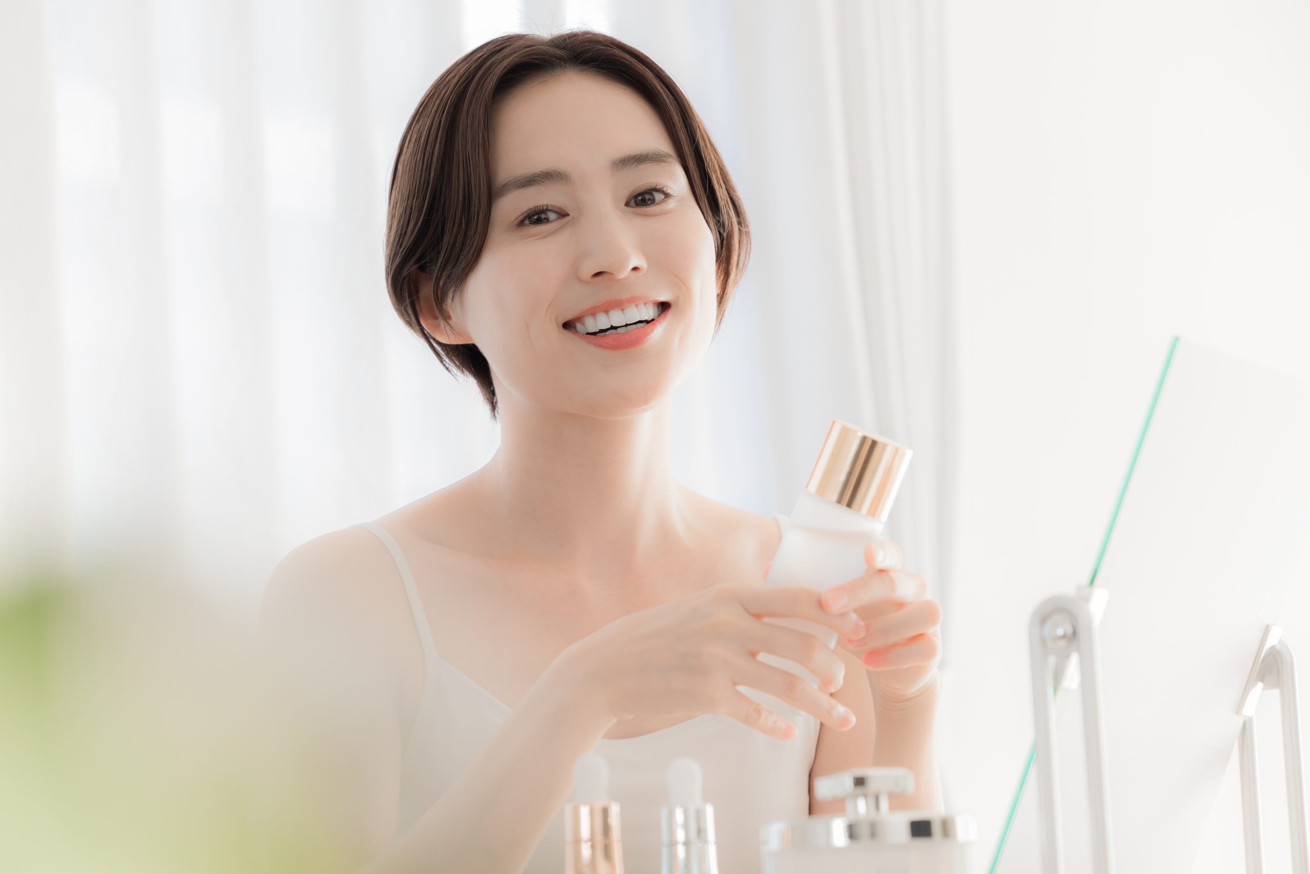 スキンケア用品を持つ女性