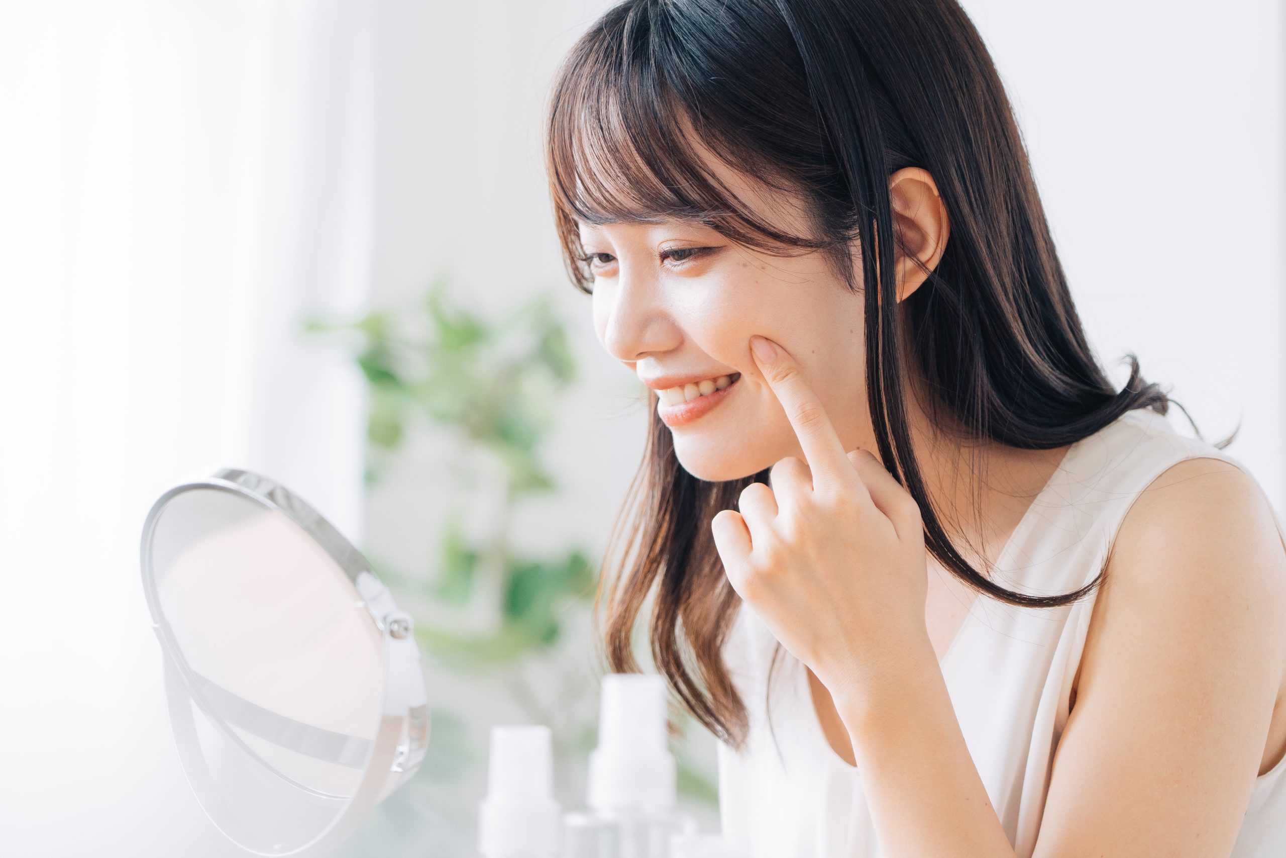 鏡で肌を確認する女性