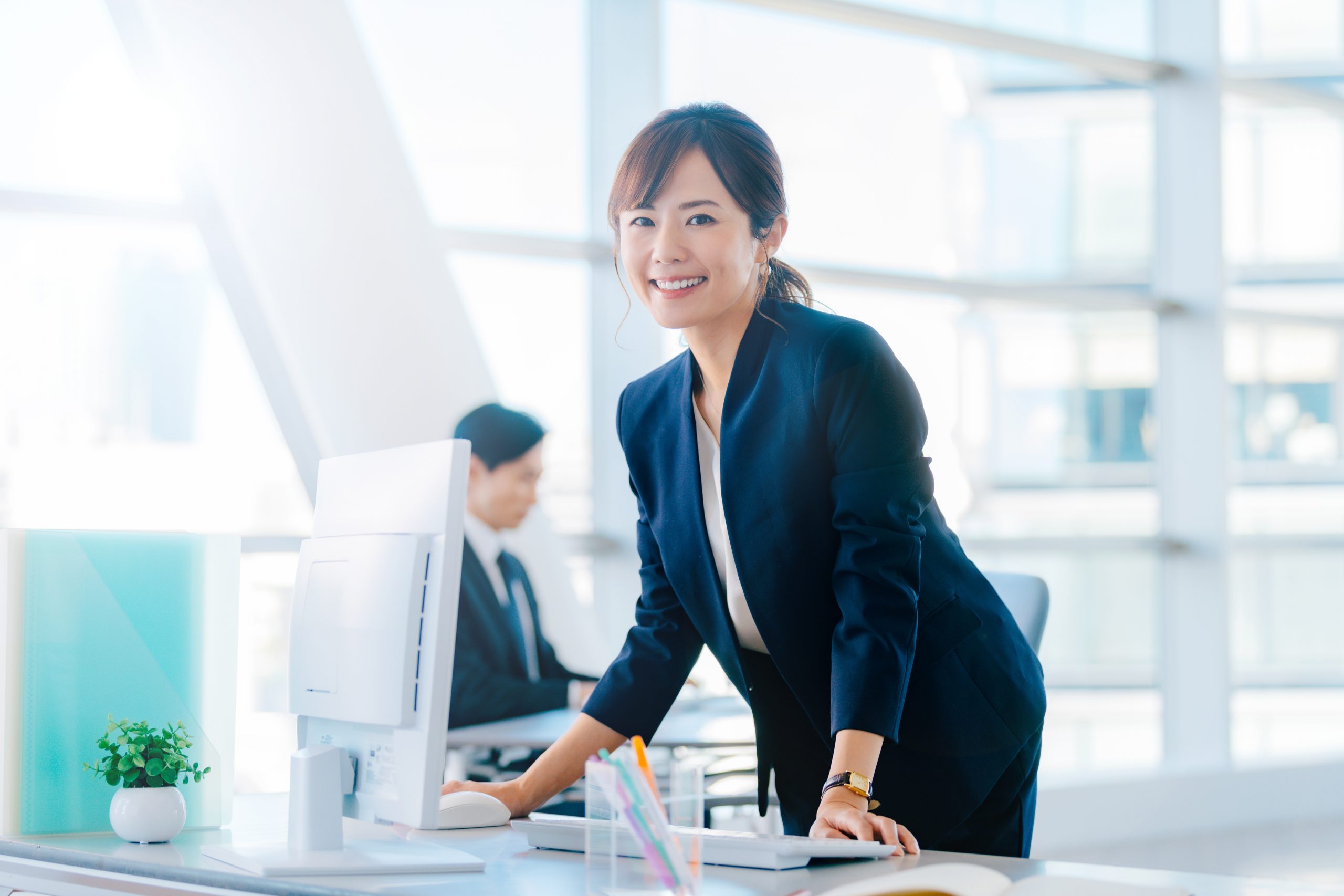 デスクワークの合間に立ち上がる女性