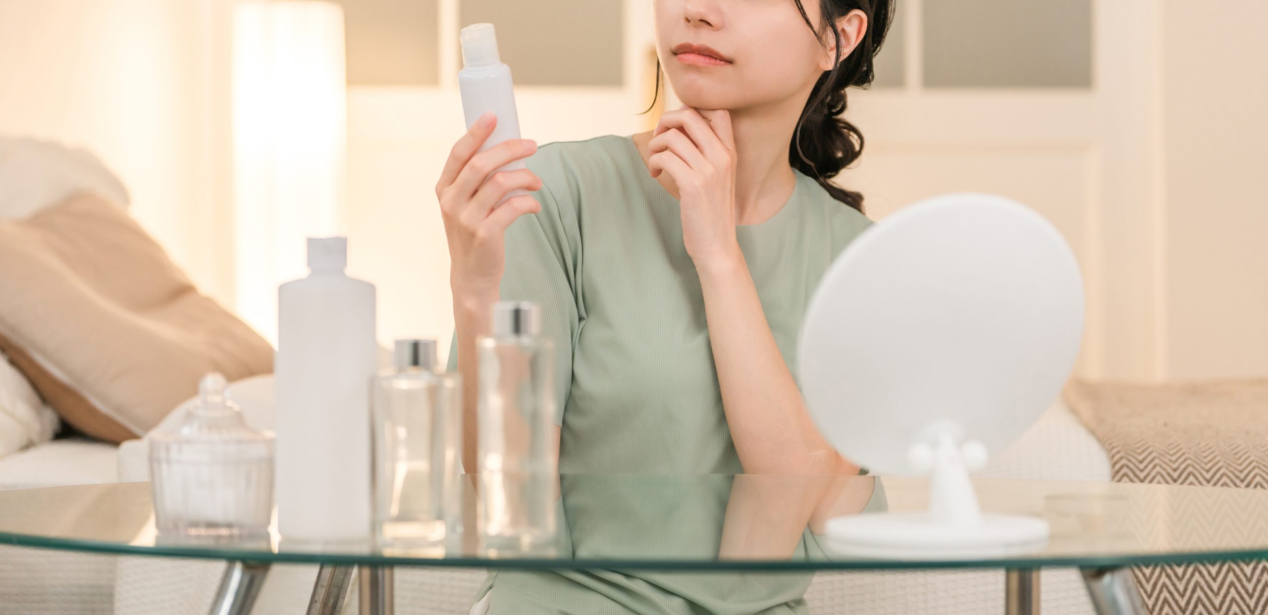 スキンケア用品を手に取る女性