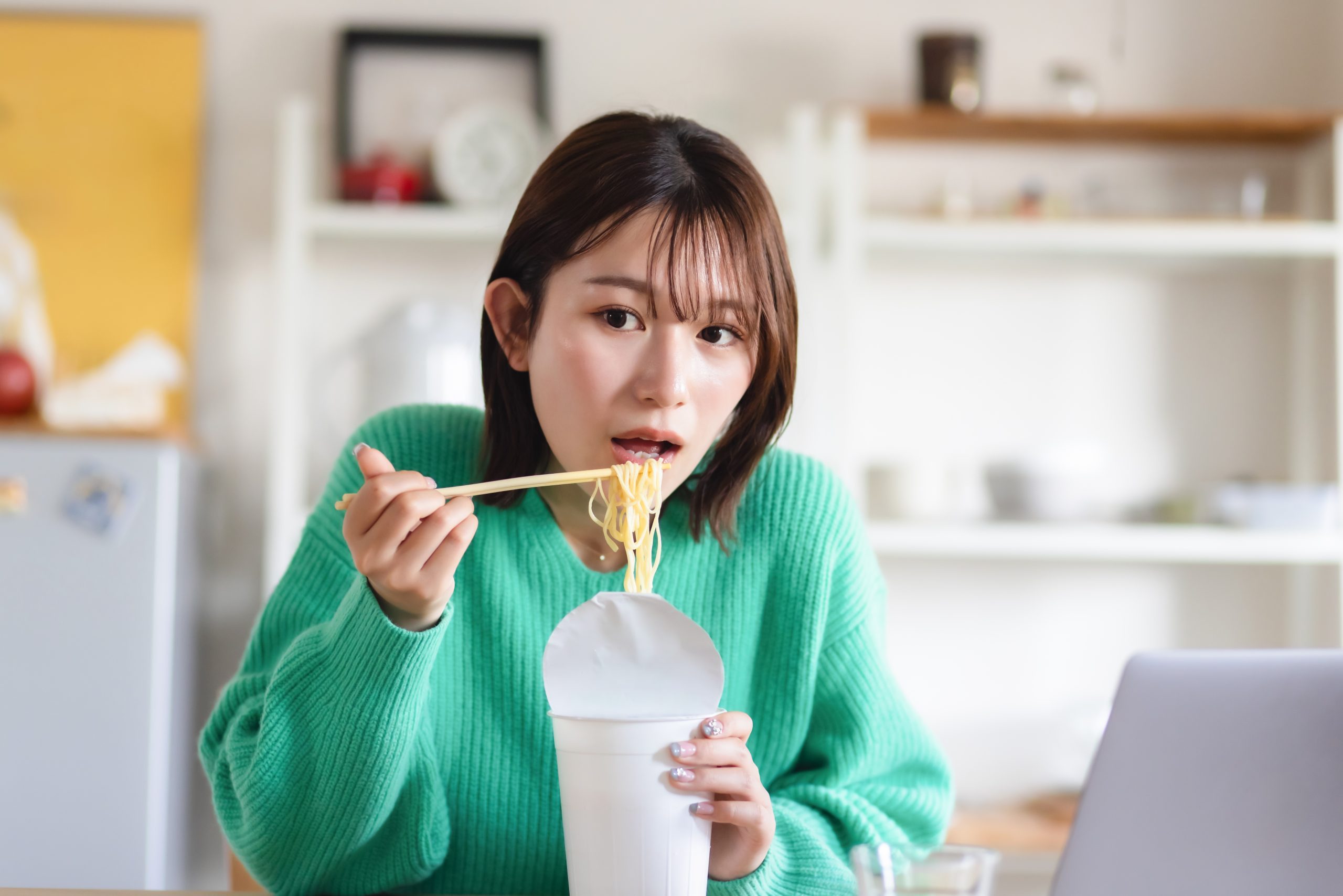 カップラーメンを食べる女性